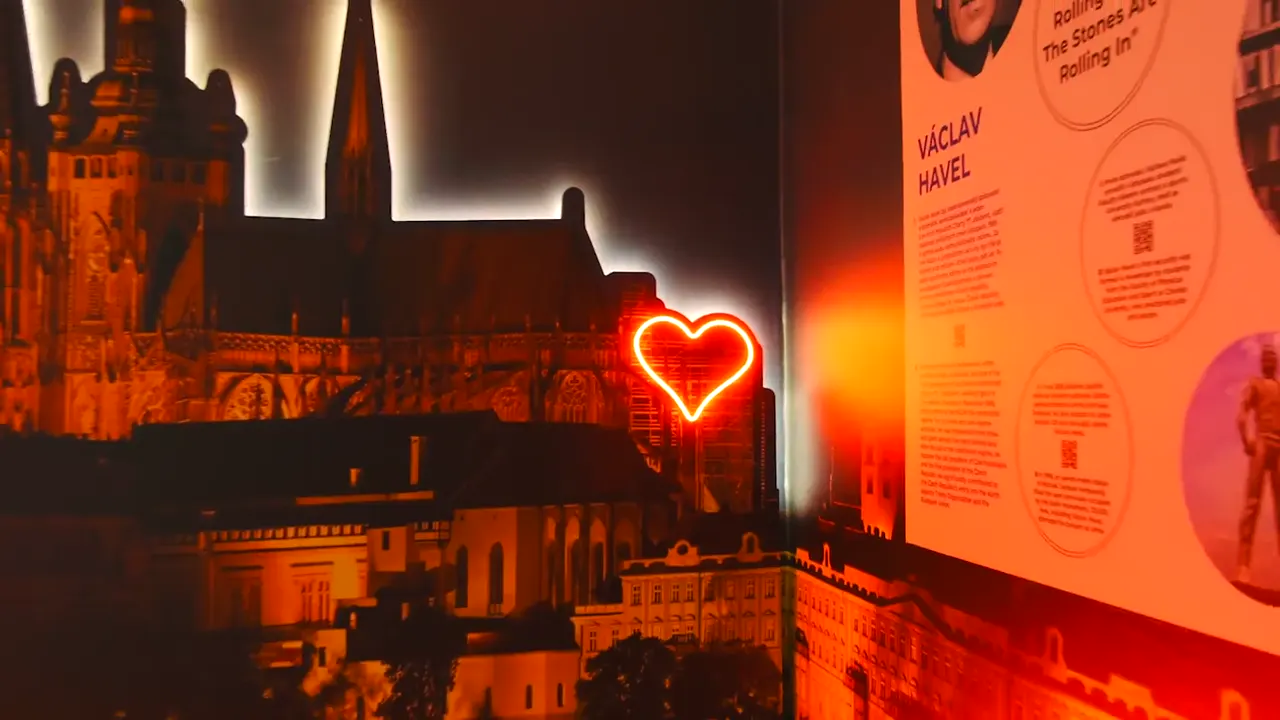 Panorama Pražského hradu s neonovým srdcem v expozici Story of Prague, vedle panel o Václavu Havlovi